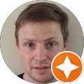 A close up of a man 's face in a circle with an orange star.