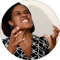 A woman is making a funny face with her hands in the air.