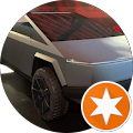 A tesla cybertruck is parked in a circle with an orange star.