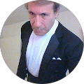 A man in a tuxedo and white shirt is standing in a circle.