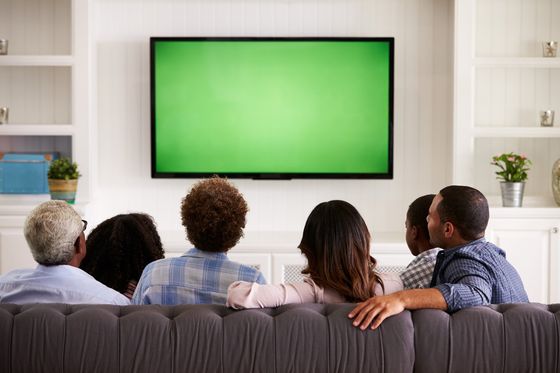 persone che guardano la televisione con uno schermo verde