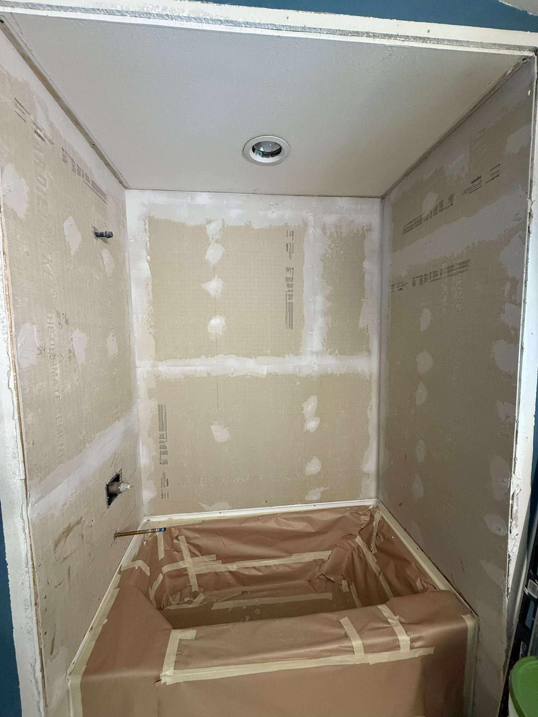 Newly constructed shower enclosure with drywall, awaiting tiling.