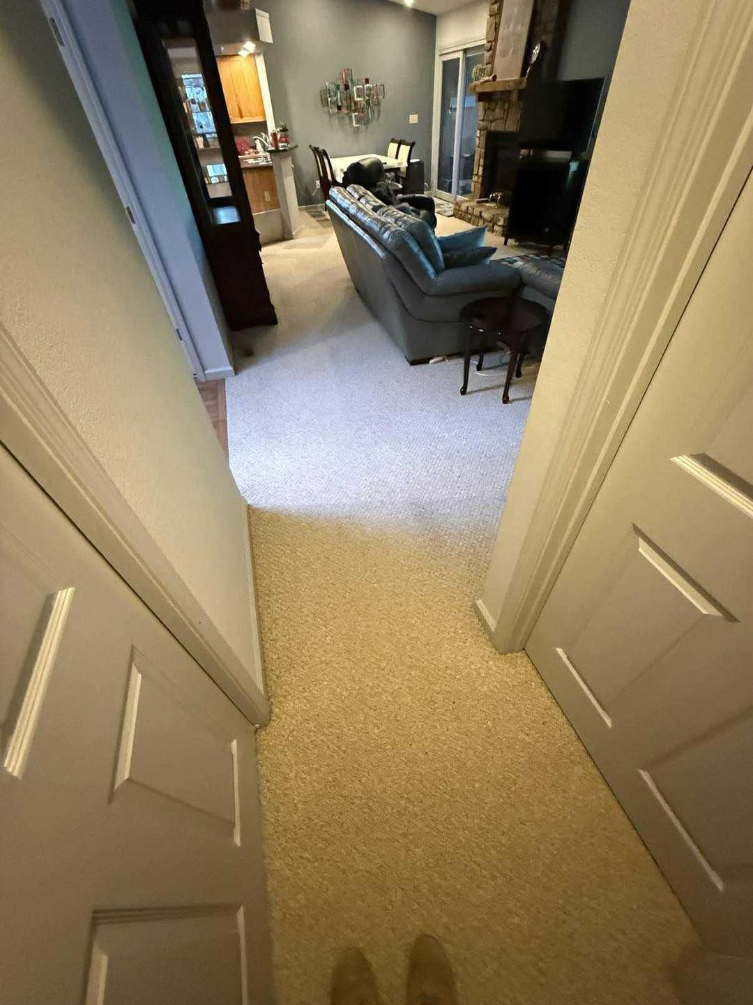 View from a doorway into a living room with sofa, fireplace, and carpeted floor.