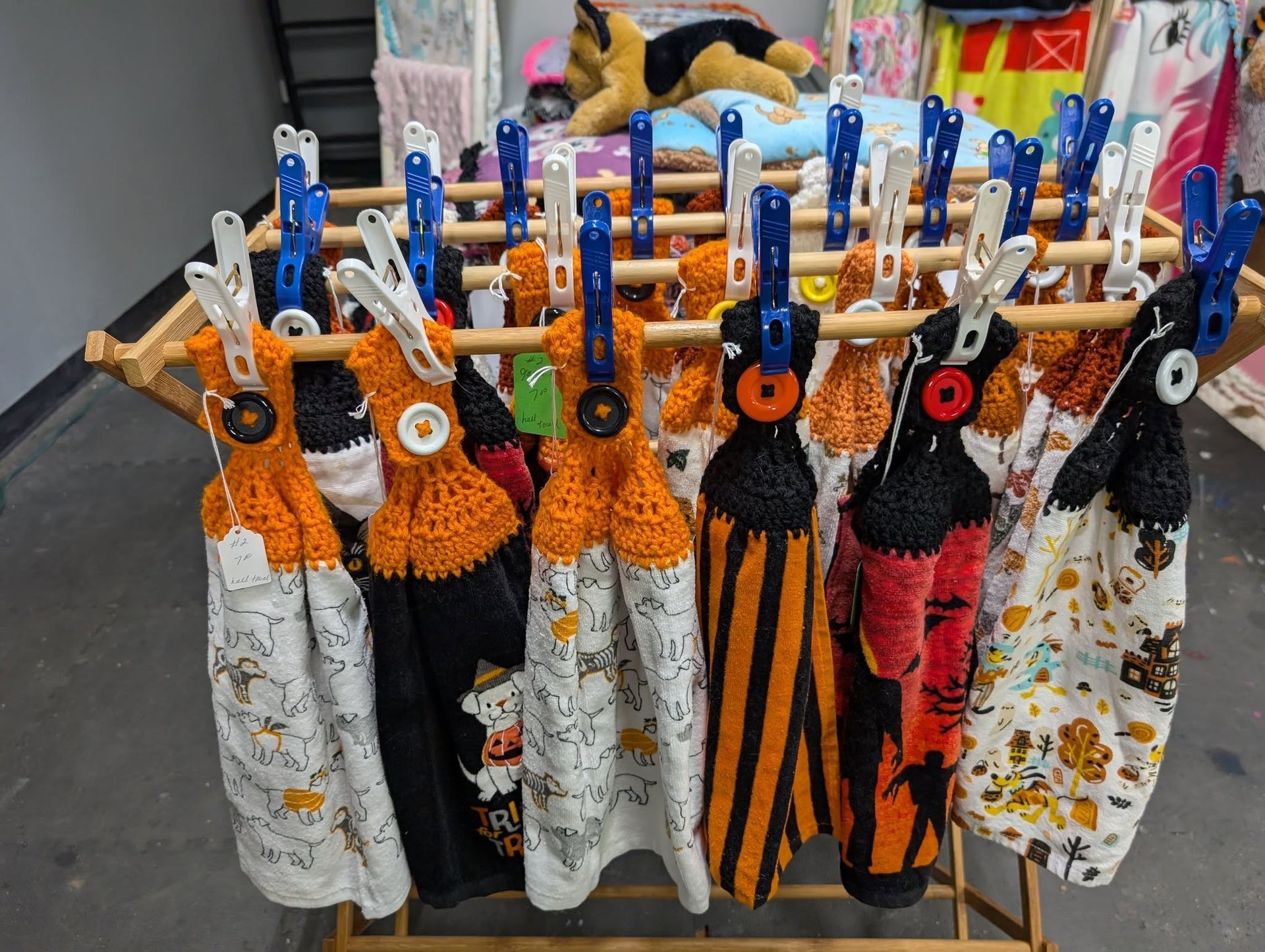 Crocheted Halloween kitchen towels clipped to a wooden drying rack.