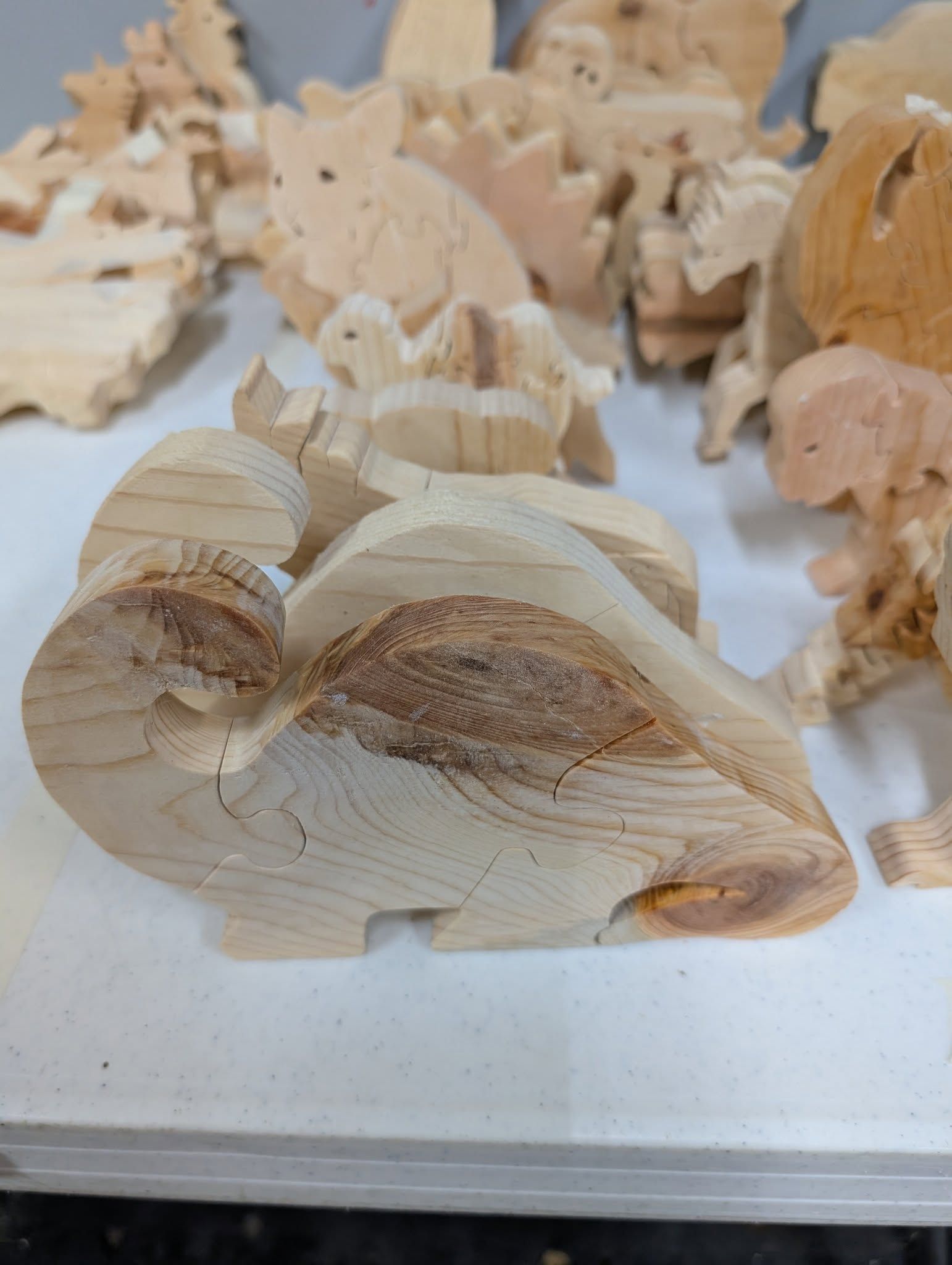 Wooden carved turtles and other animal shapes on a white surface.