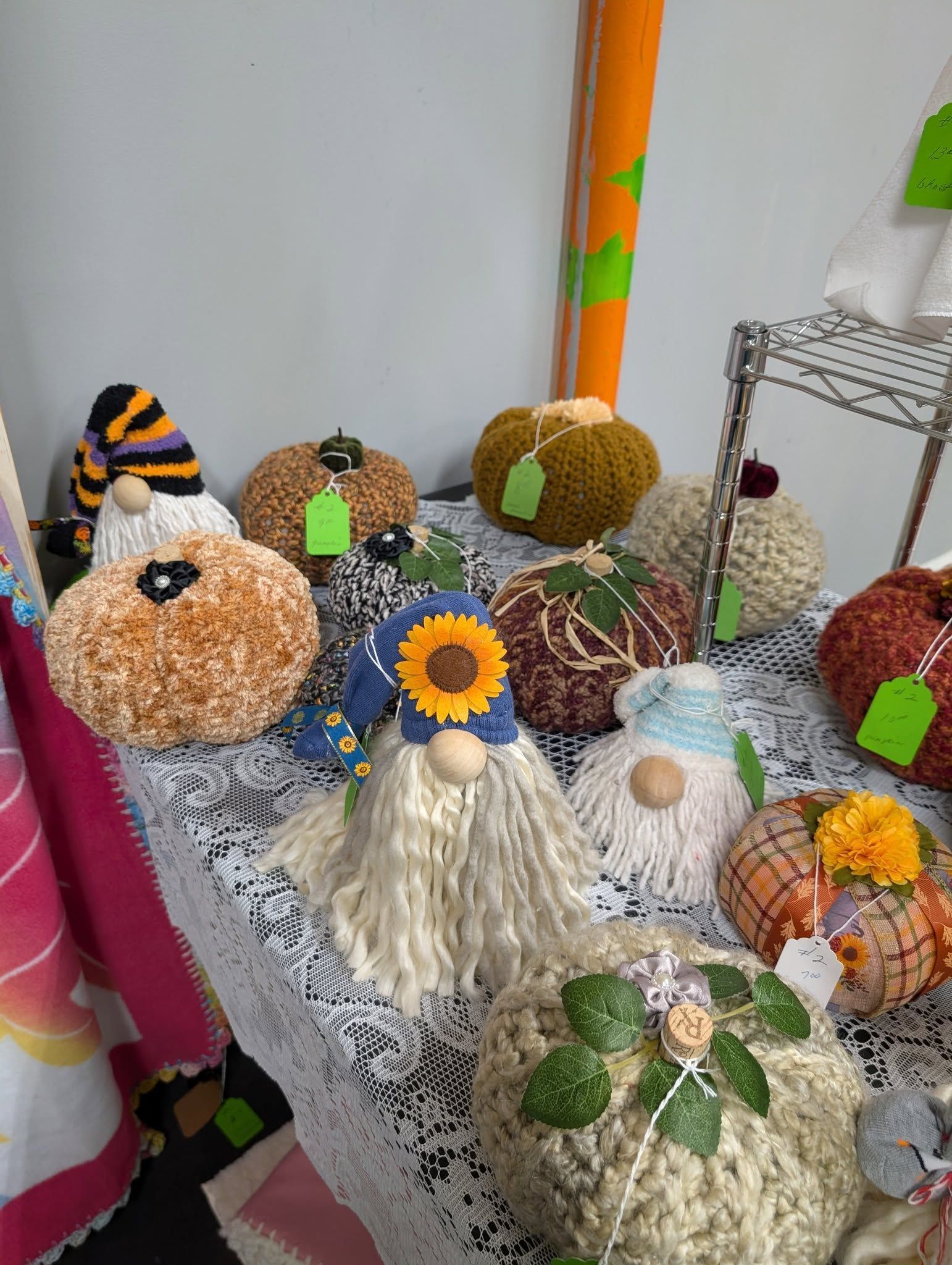 Handmade pumpkin and gnome decorations on display at a craft fair.
