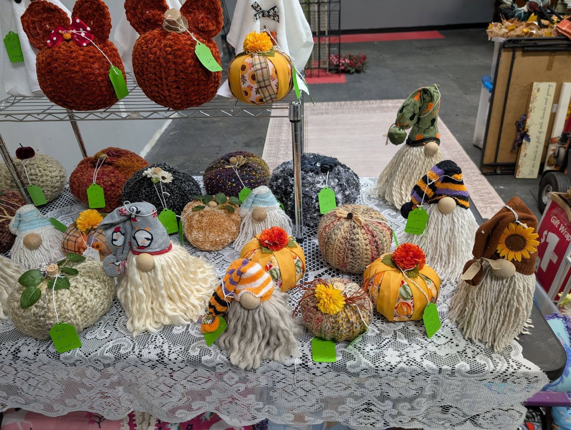 Display of autumn-themed crafts, including pumpkins and gnomes, on a table.