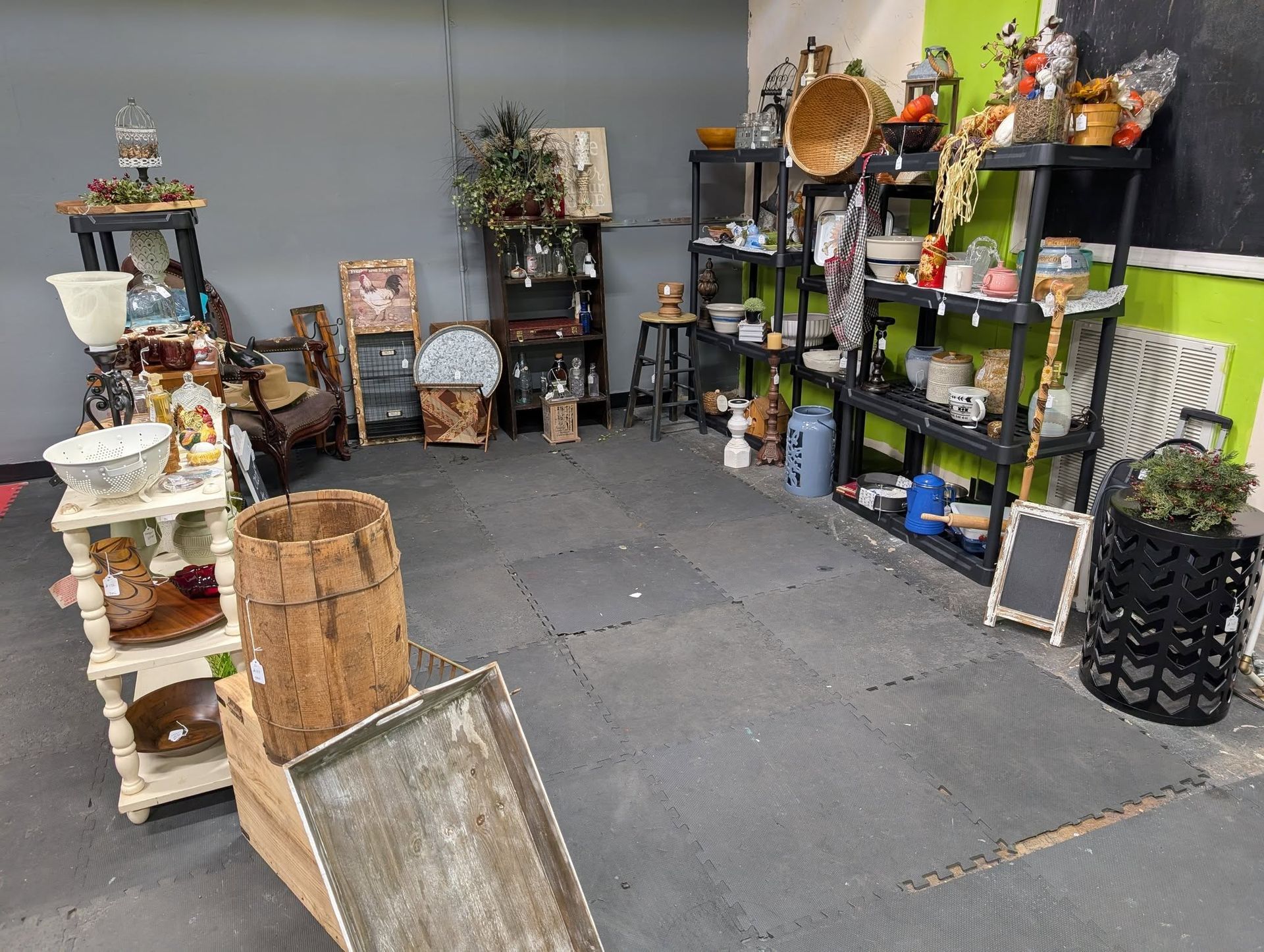 Shop interior with items for sale on shelves and displays. Gray floors, neutral walls.