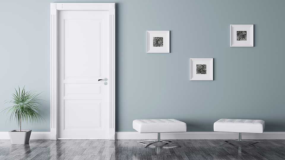 A white door is in a room with a blue wall.