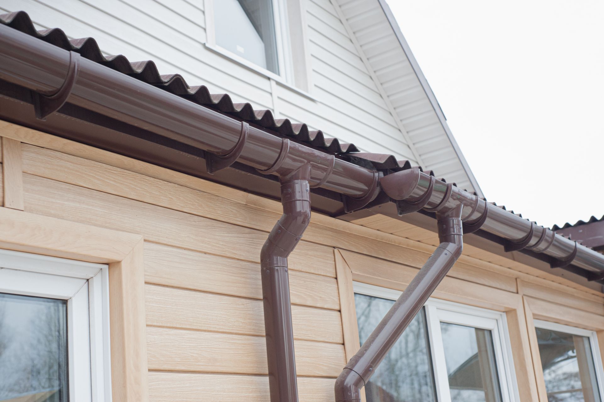 a brown gutter is attached to the side of a house .