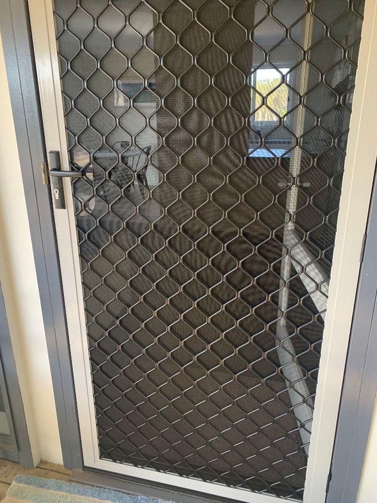 A Living Room With a Red Couch and Sliding Glass Doors — Whitsunday Screens & Grilles In Proserpine, QLD