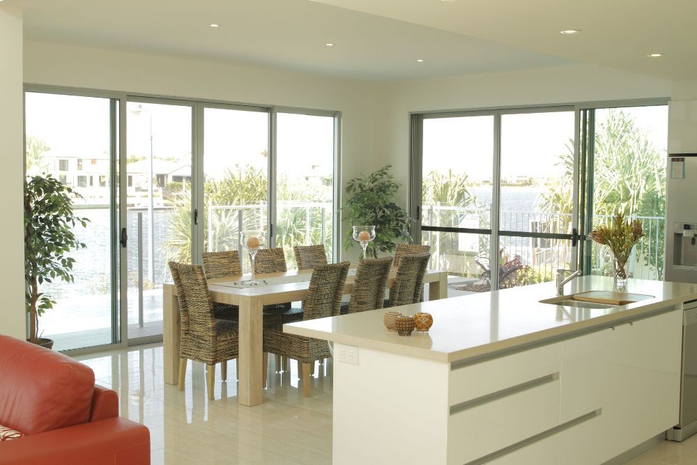A Living Room With a Red Couch and Sliding Glass Doors — Whitsunday Screens & Grilles In Proserpine, QLD