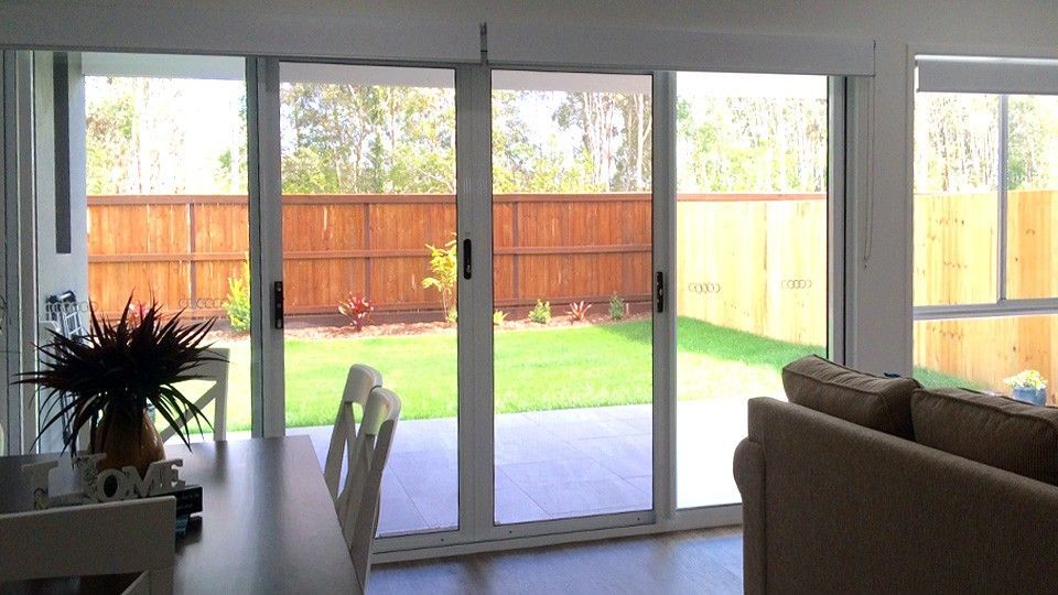 The Front Door of a House With a Glass Door and a Wooden Fence — Whitsunday Screens & Grilles In Proserpine, QLD