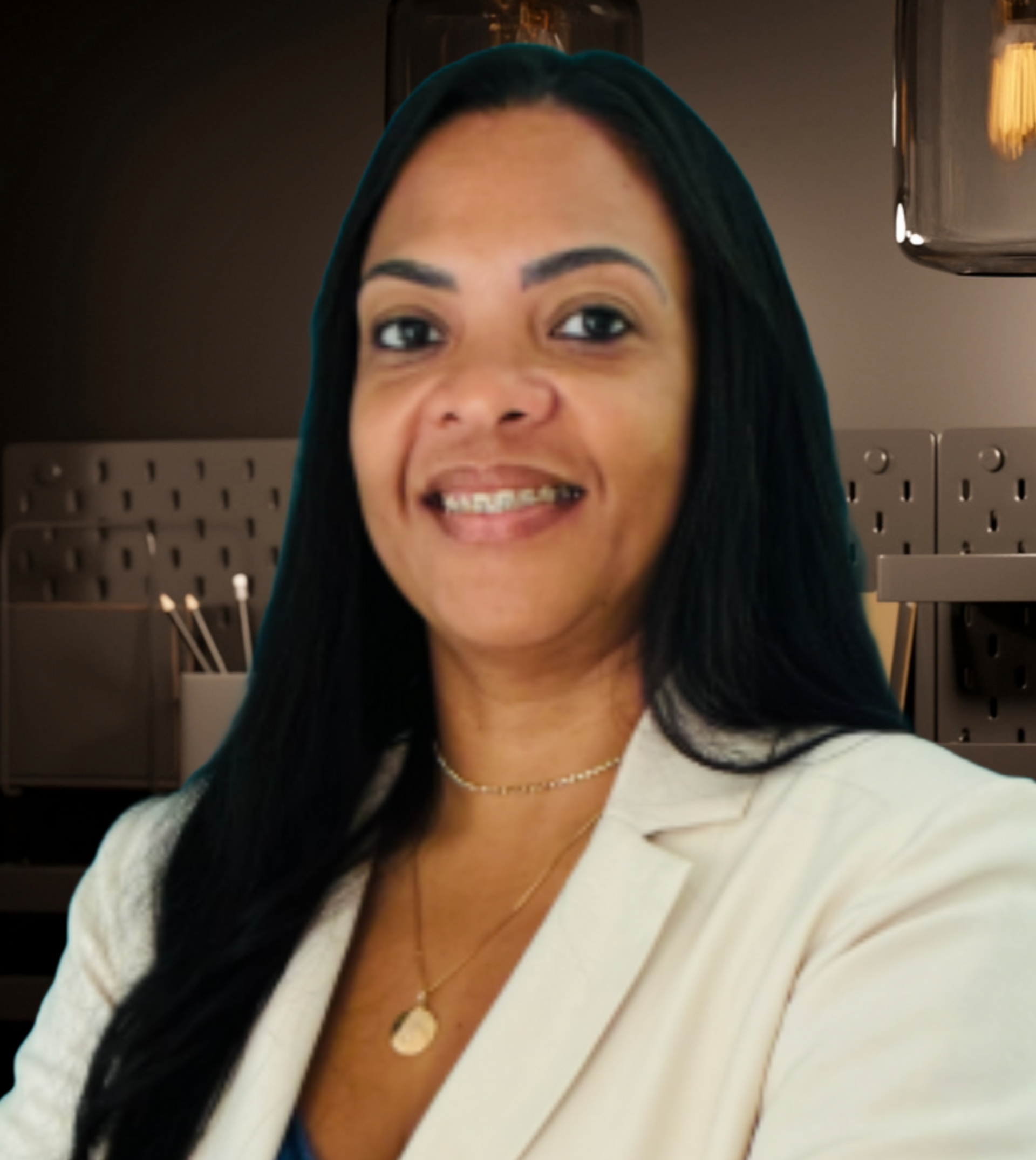 Retrato de uma pessoa sorridente vestindo um blazer branco, sentada em um ambiente interno moderno.