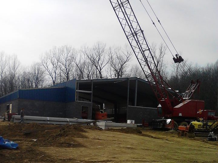 A concrete mixer truck is parked in front of a construction site.
