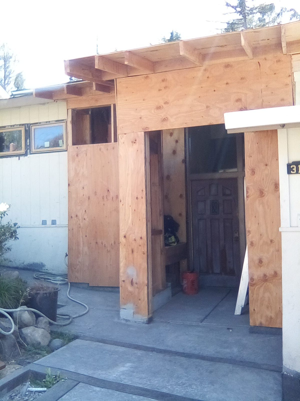 A room with a wooden floor and stairs under construction.