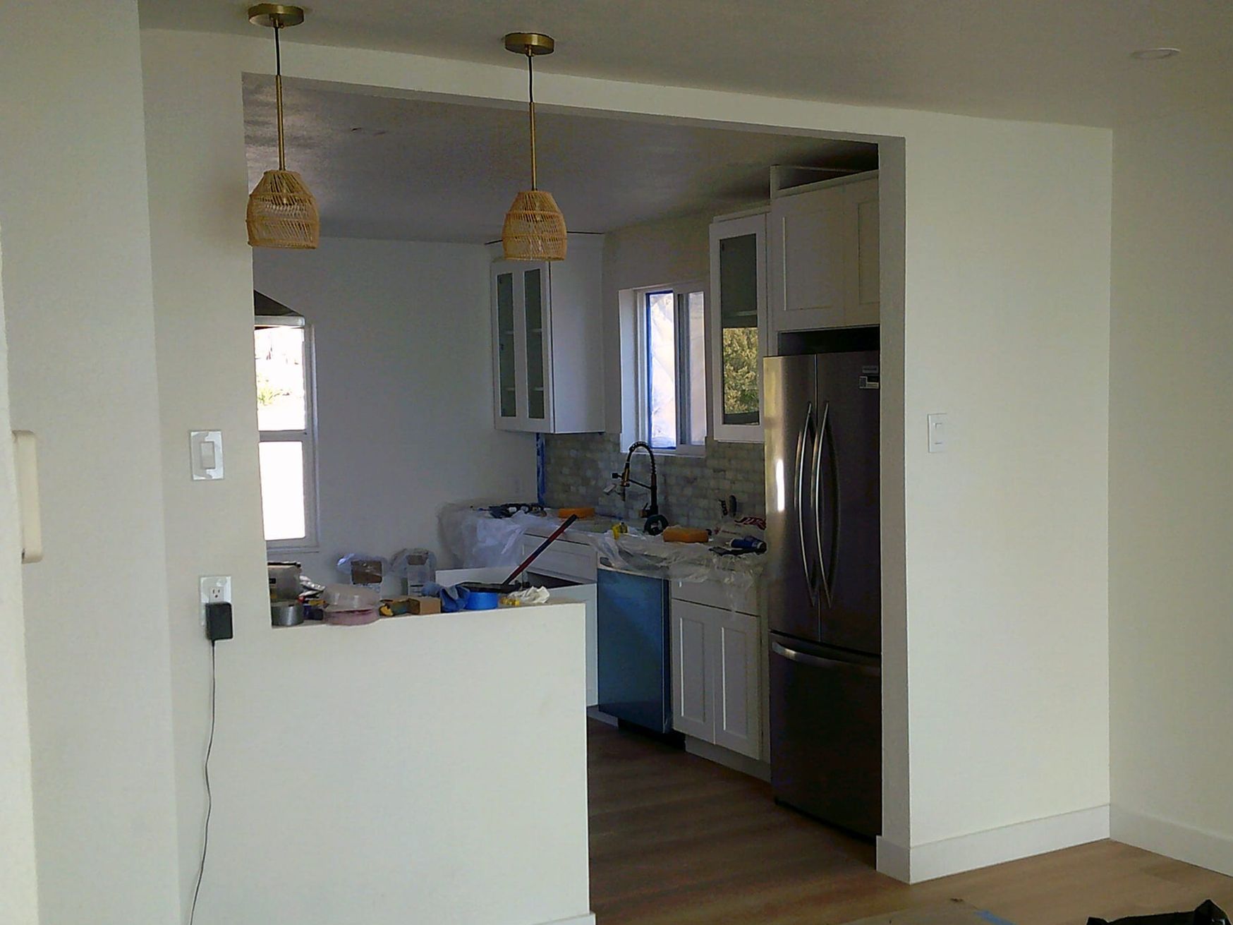 A kitchen with white cabinets , stainless steel appliances , and a large island.