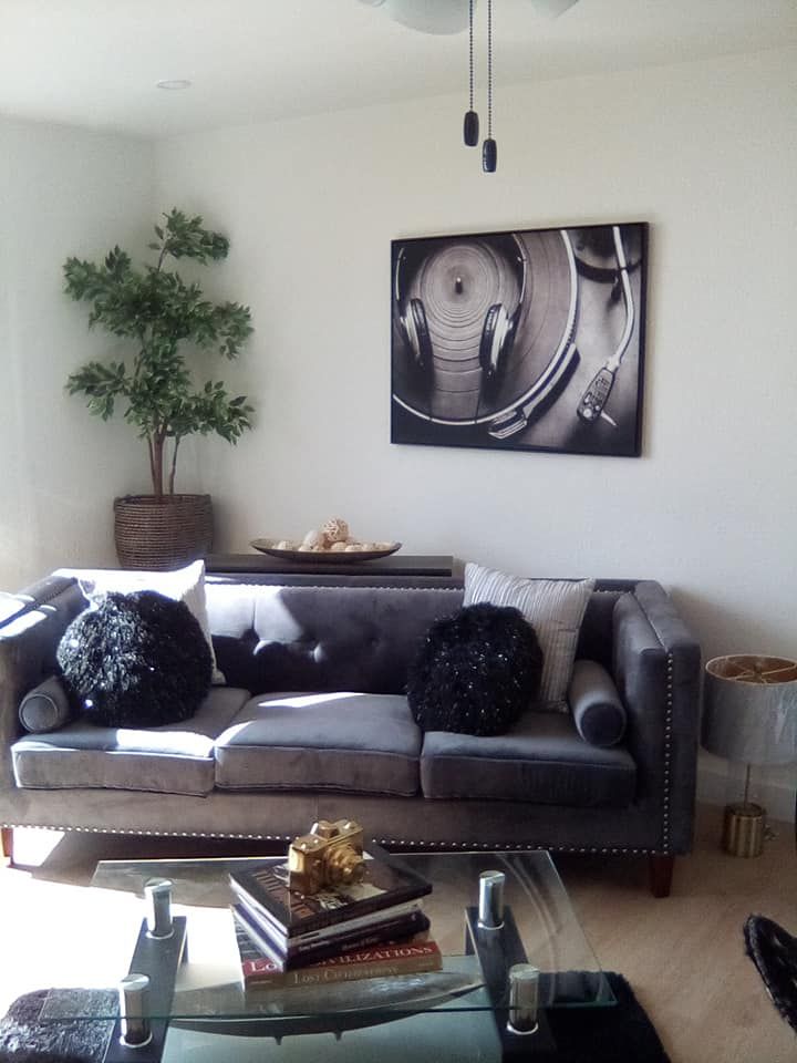 A black house with a patio and chairs in front of it.