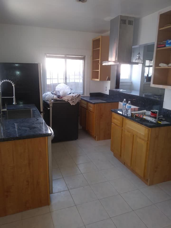 Kitchen renovation with cabinets, appliances, countertops, stainless steel hood, and open window.