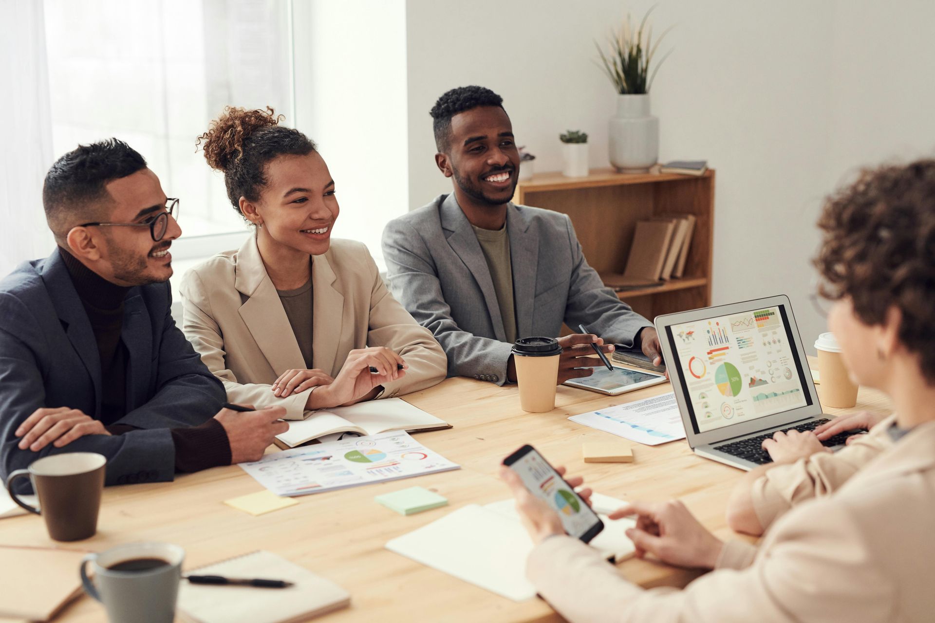 A group of people are sitting around a table having a meeting.