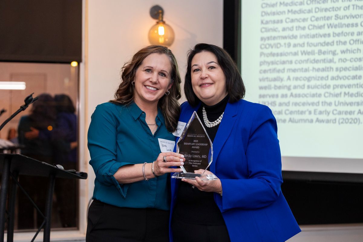 A man in a suit and tie is smiling for the camera