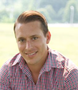 A man in a plaid shirt is smiling for the camera.