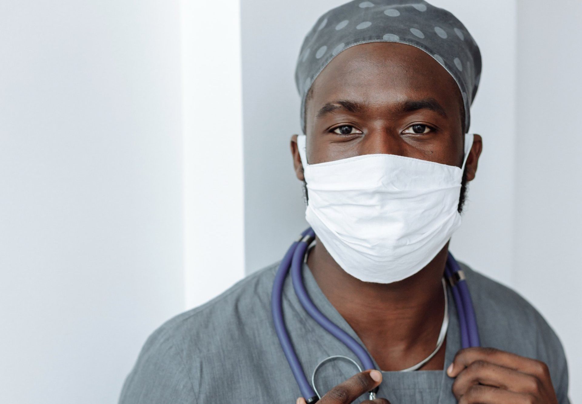 A doctor wearing a mask and a stethoscope around his neck.