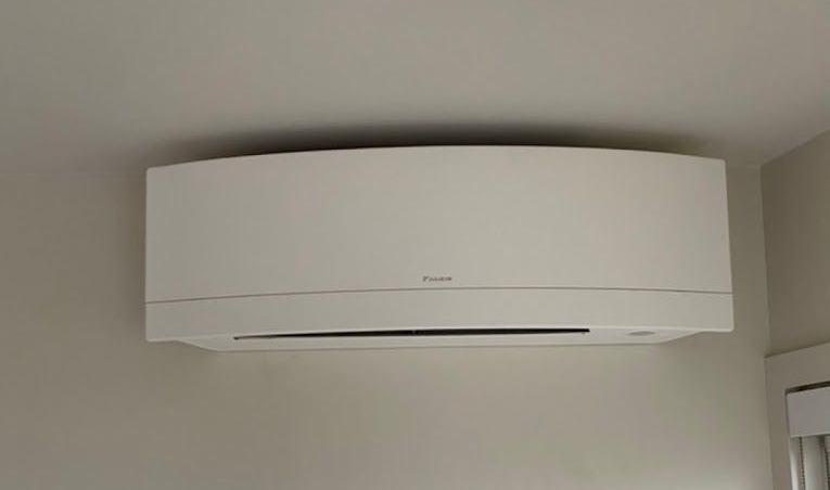 White air conditioning unit mounted on a light gray wall in Vancouver home
