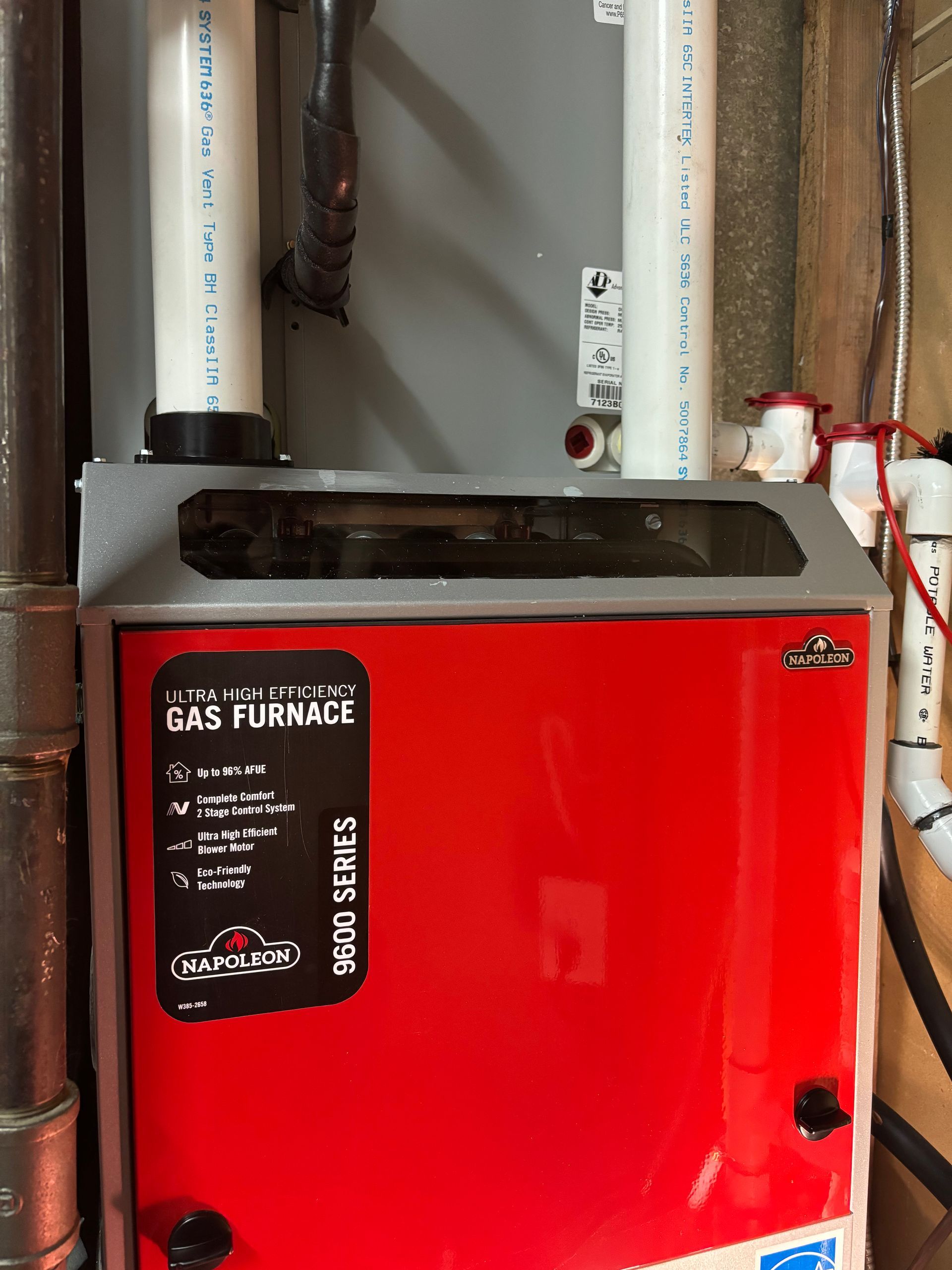 Napoleon gas furnace with white PVC pipes in a basement in Vancouver