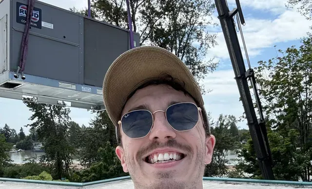 Very happy HVAC technician smiling and wearing sunglasses