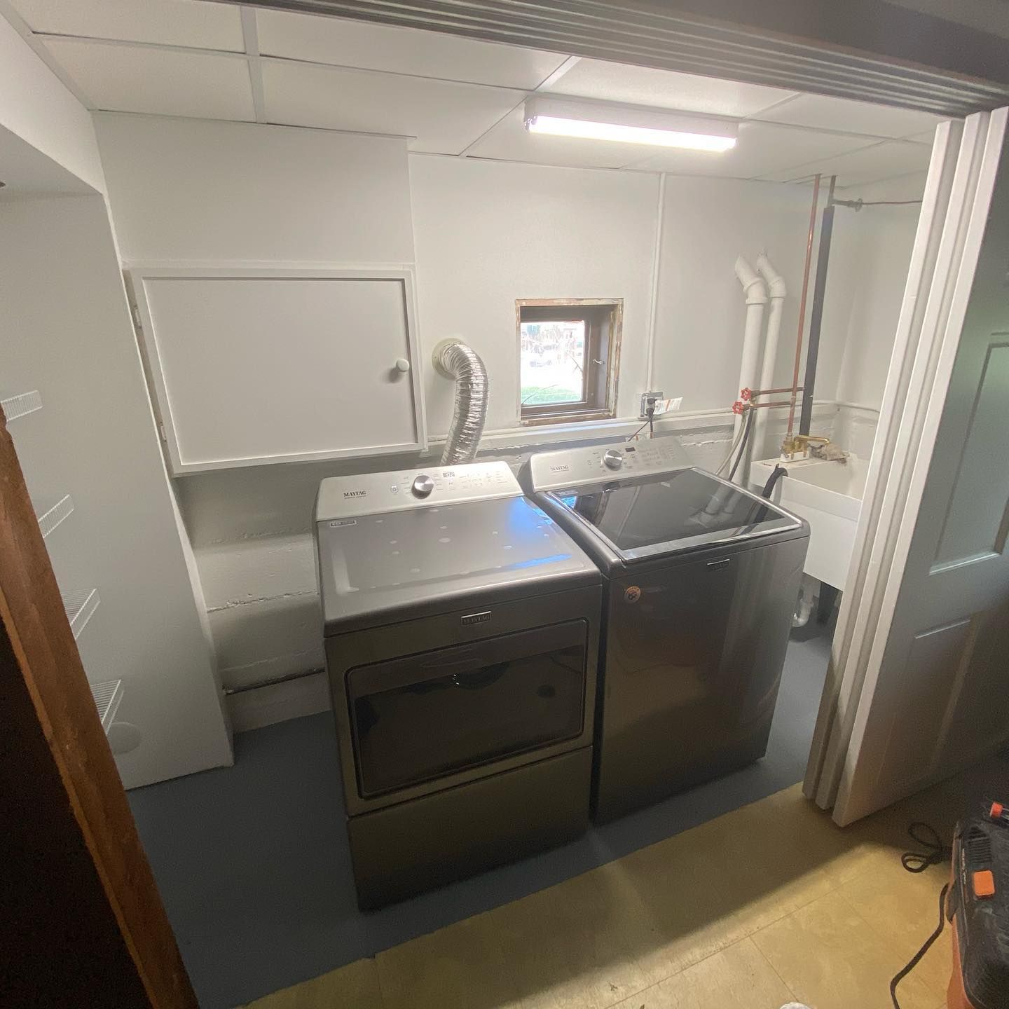 A laundry room with a washer and dryer and a sink.