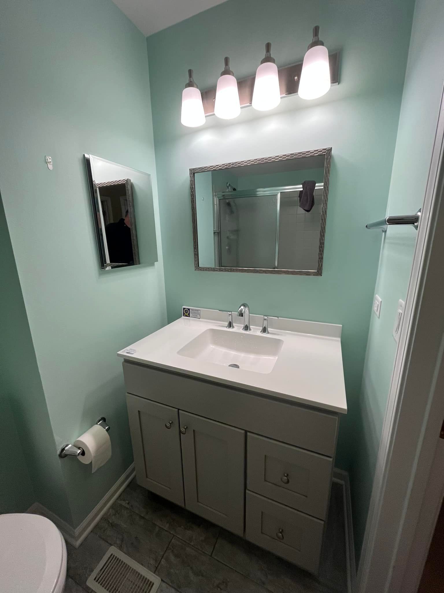 A bathroom with a sink , mirror and toilet.