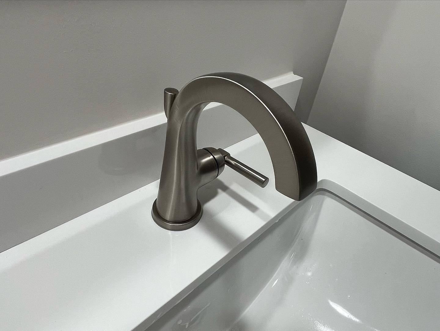 A bathroom sink with a stainless steel faucet