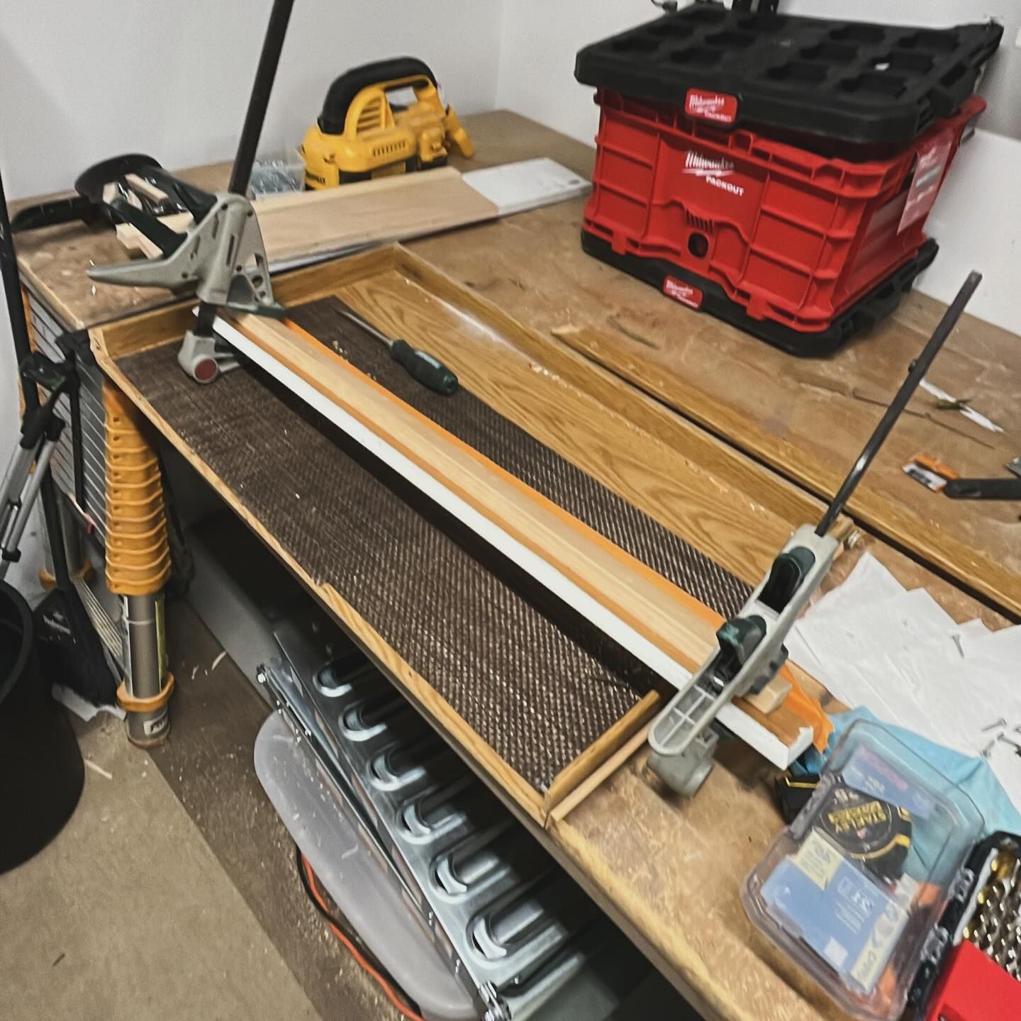 A red milwaukee toolbox sits on a wooden table