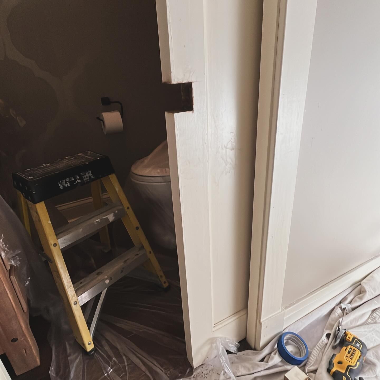 A yellow ladder is sitting in a bathroom next to a toilet.