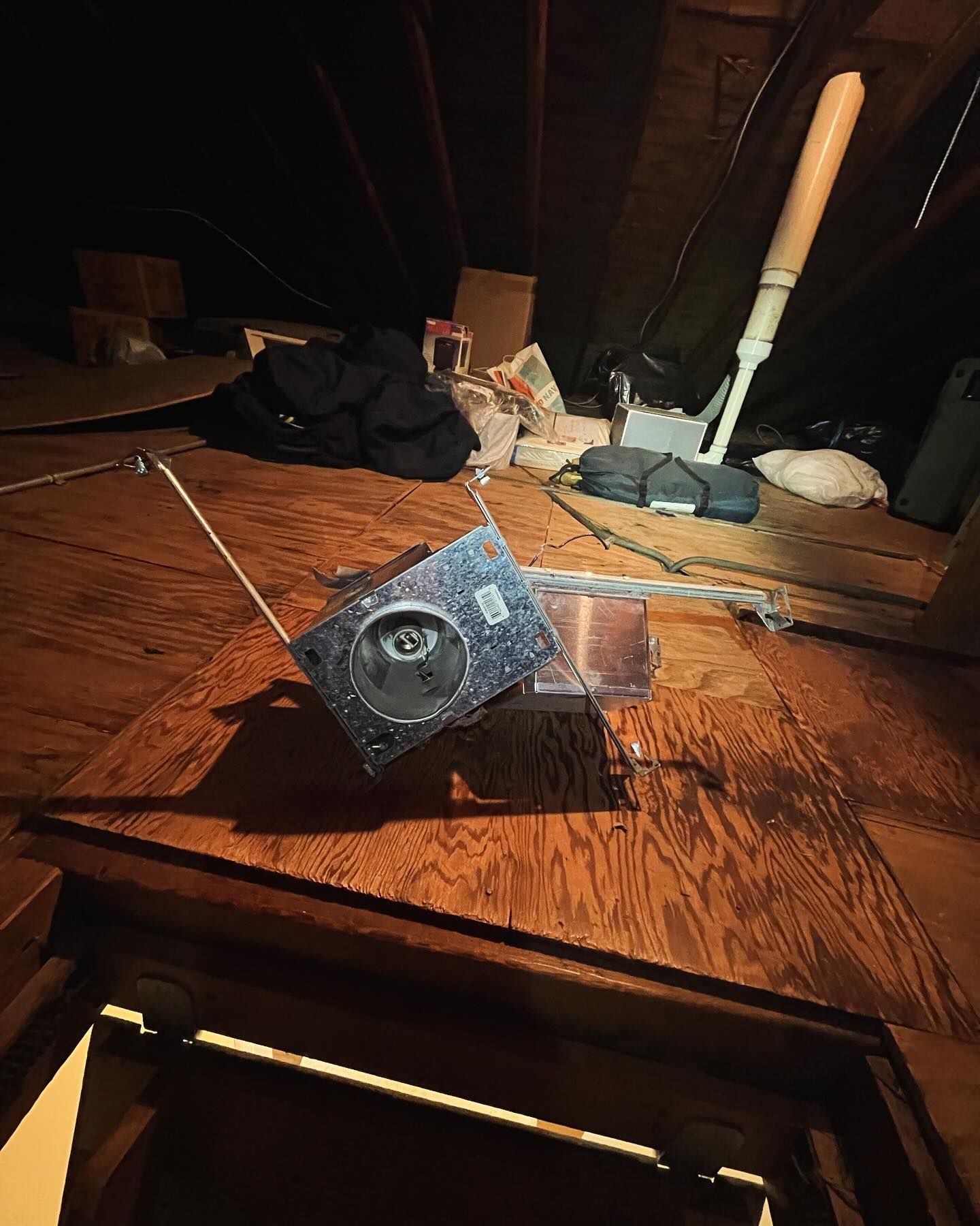 A satellite is sitting on top of a wooden table in an attic.