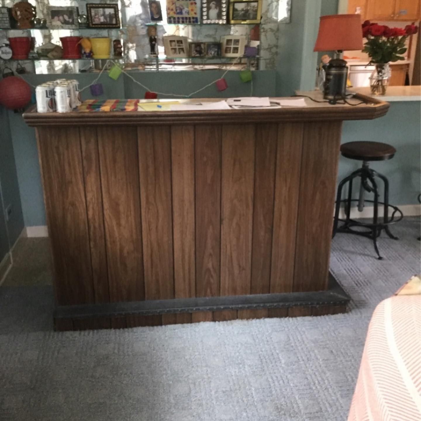 A wooden counter in a room with pictures on the wall