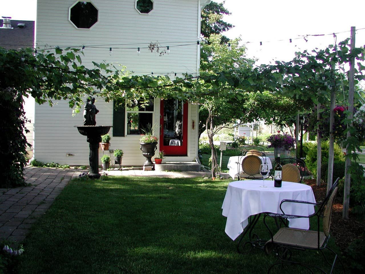 A white house with a red door and a table in front of it