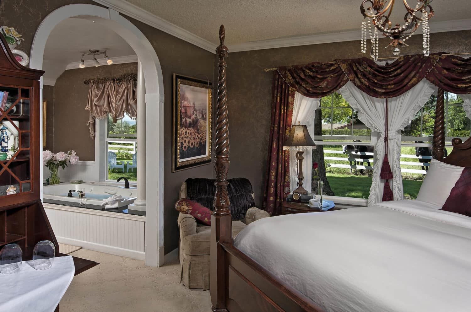 A bedroom with a four poster bed and a jacuzzi tub