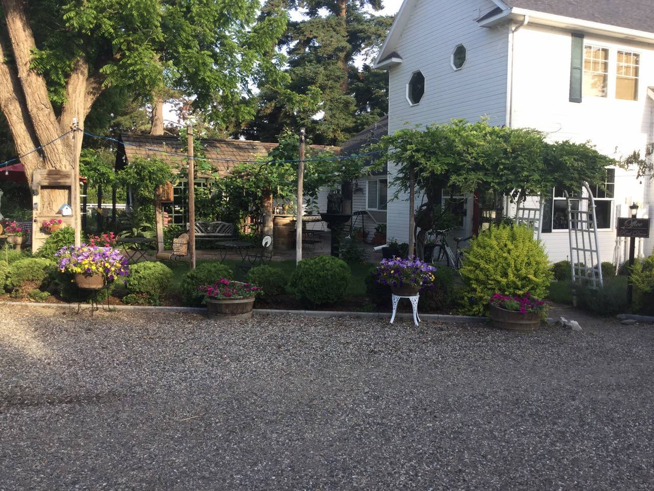 A white house with a gravel driveway in front of it