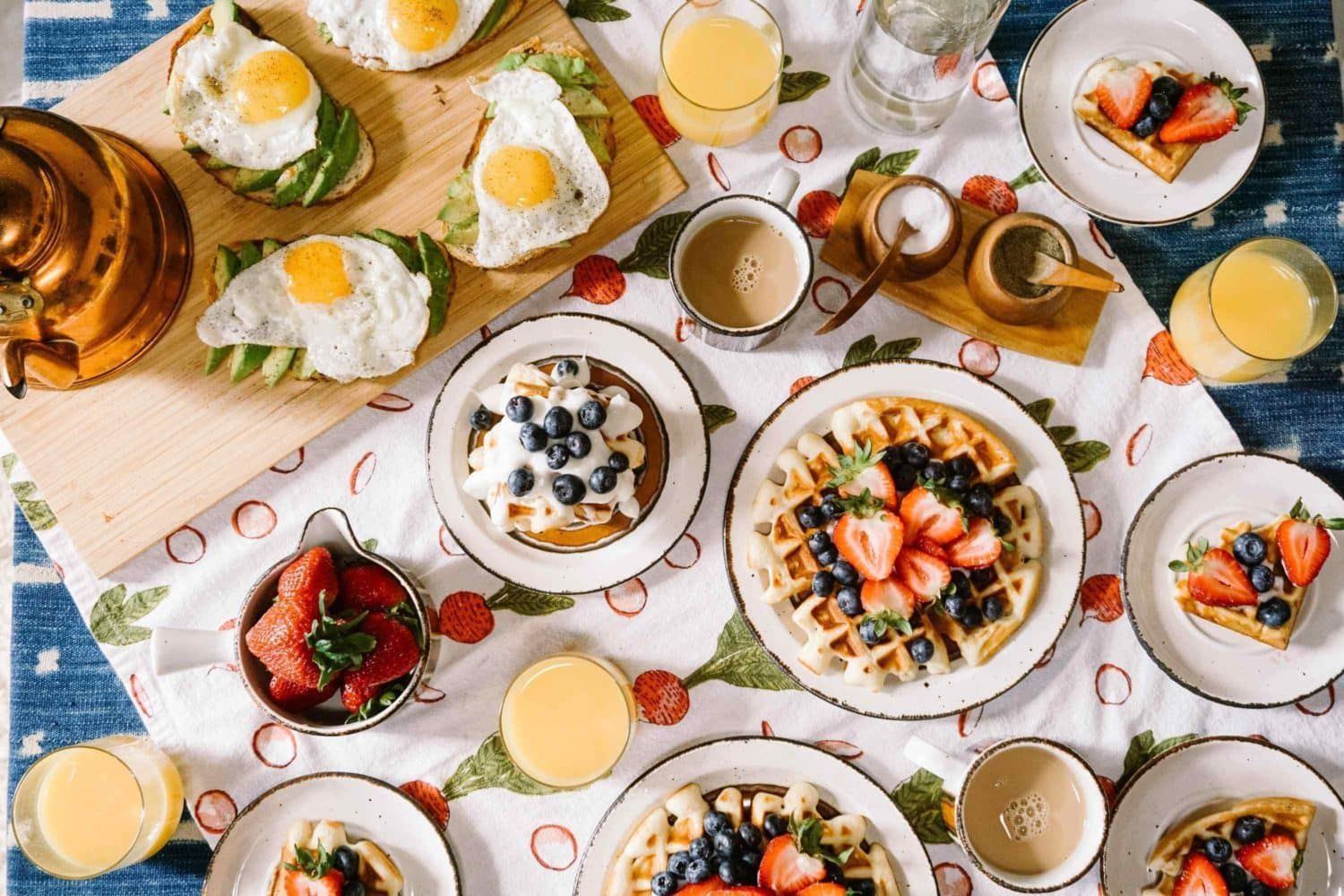 A table topped with plates of food and drinks.