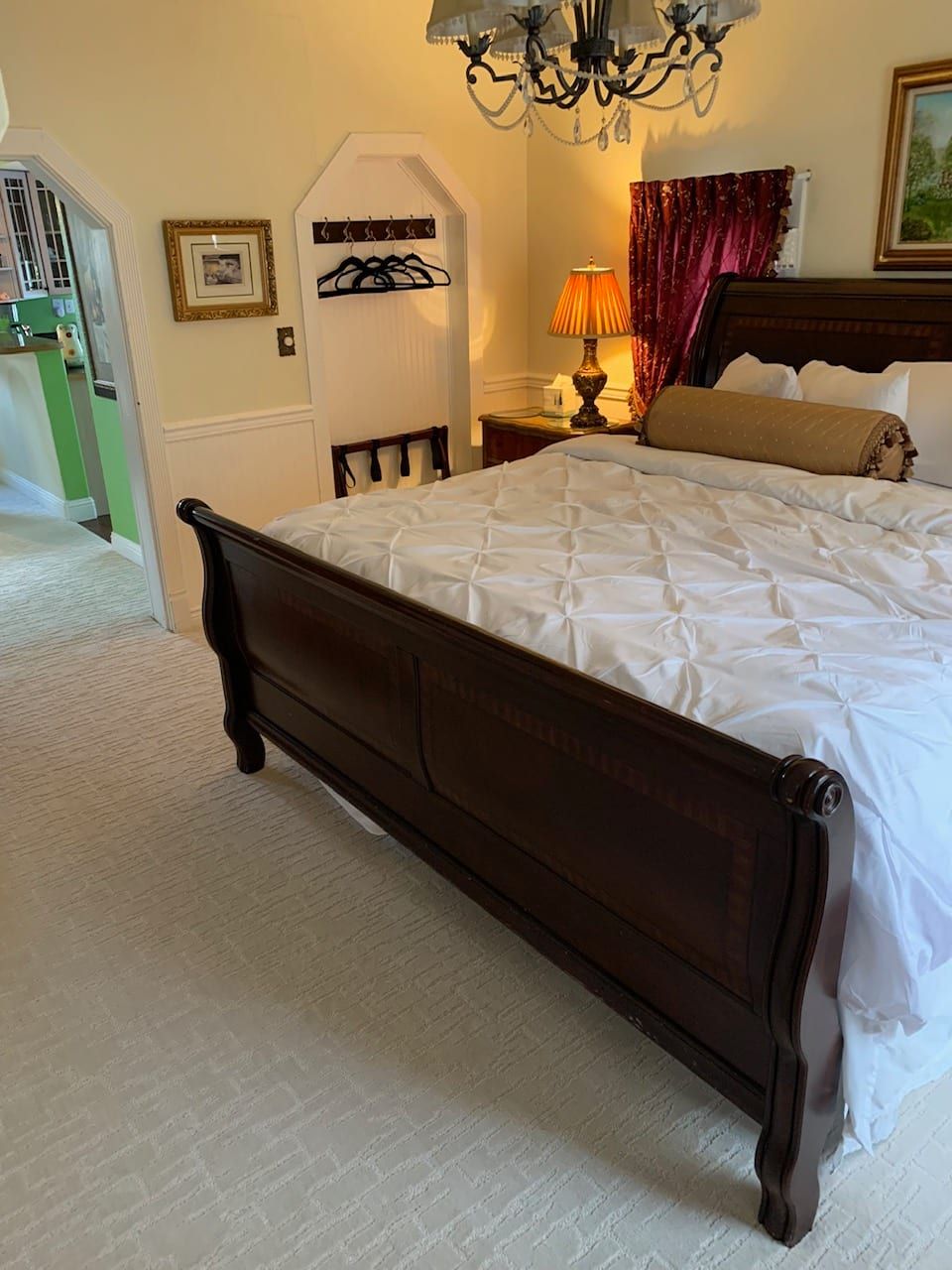 A bedroom with a king size bed and a chandelier