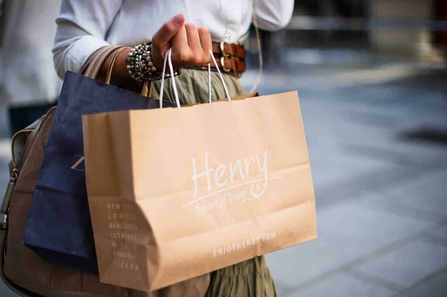 A woman is holding a shopping bag in her hands.