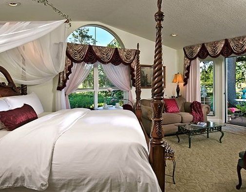 A bedroom with a canopy bed and a couch