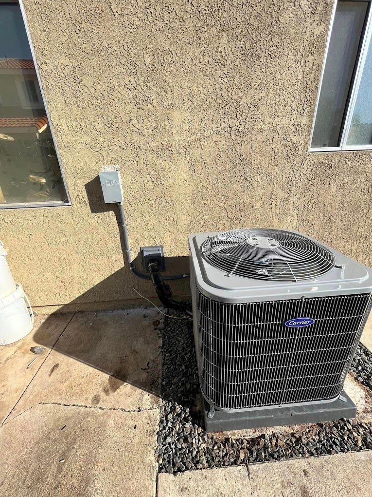 An air conditioner is sitting on the side of a building next to a window.
