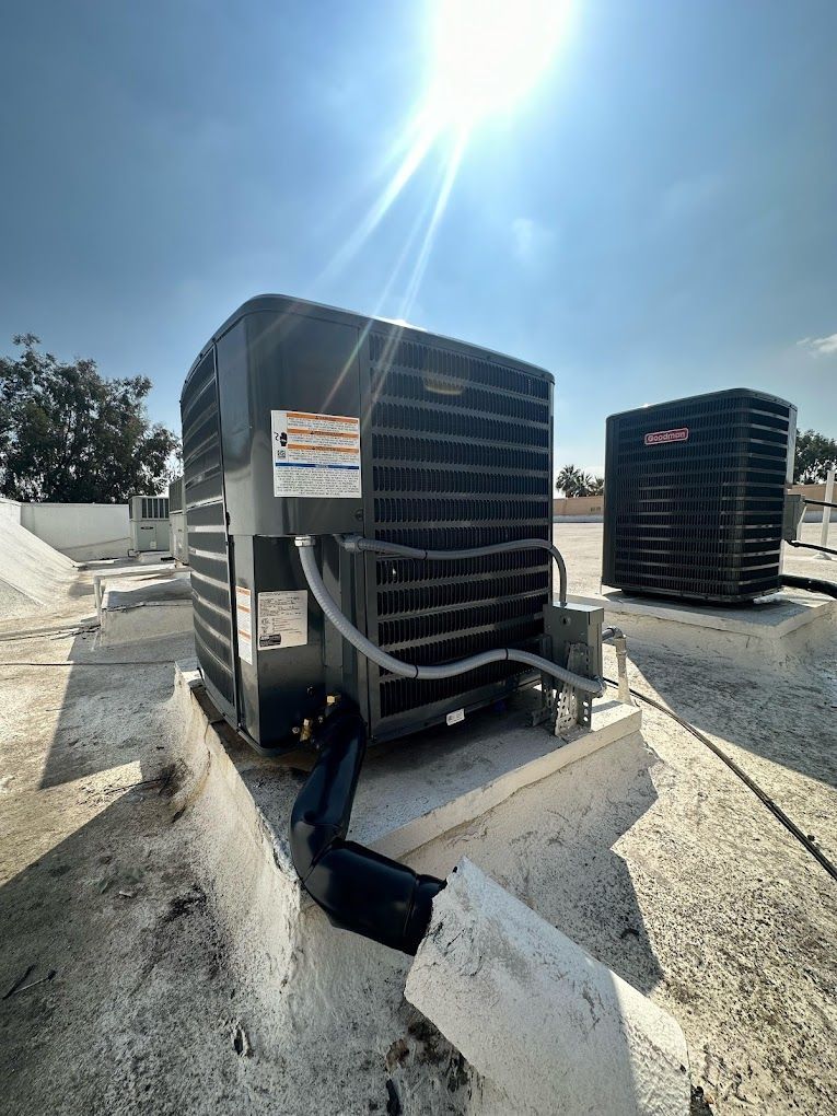 There are two air conditioners on the roof of a building.