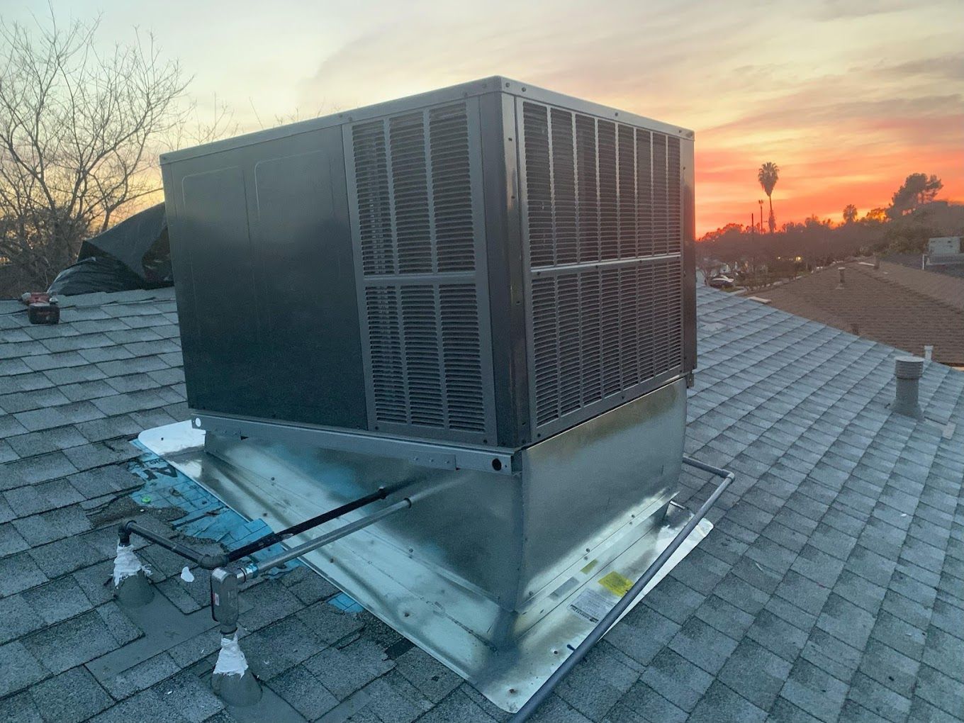 A large air conditioner is sitting on top of a roof.