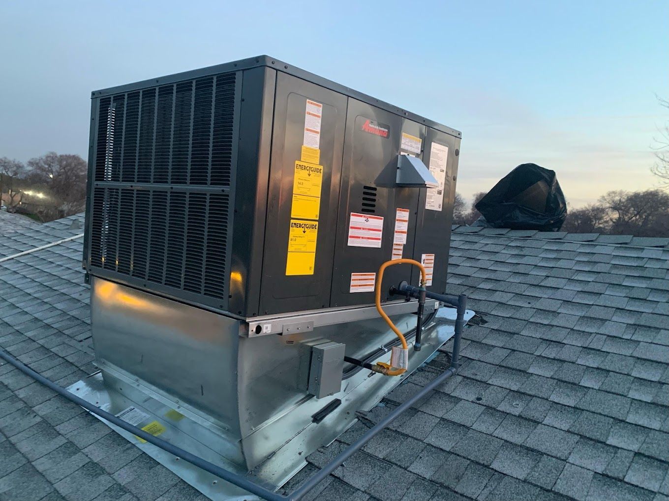 A large air conditioner is sitting on top of a roof.