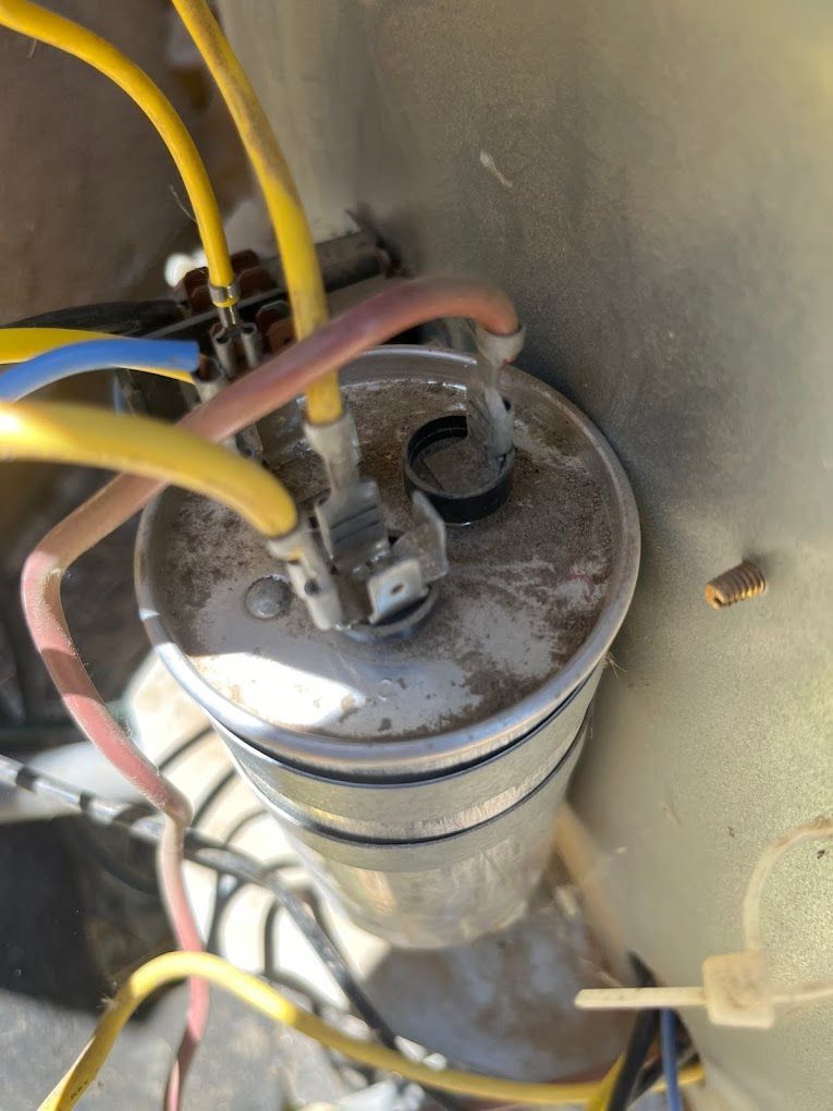 A close up of a capacitor with wires attached to it.