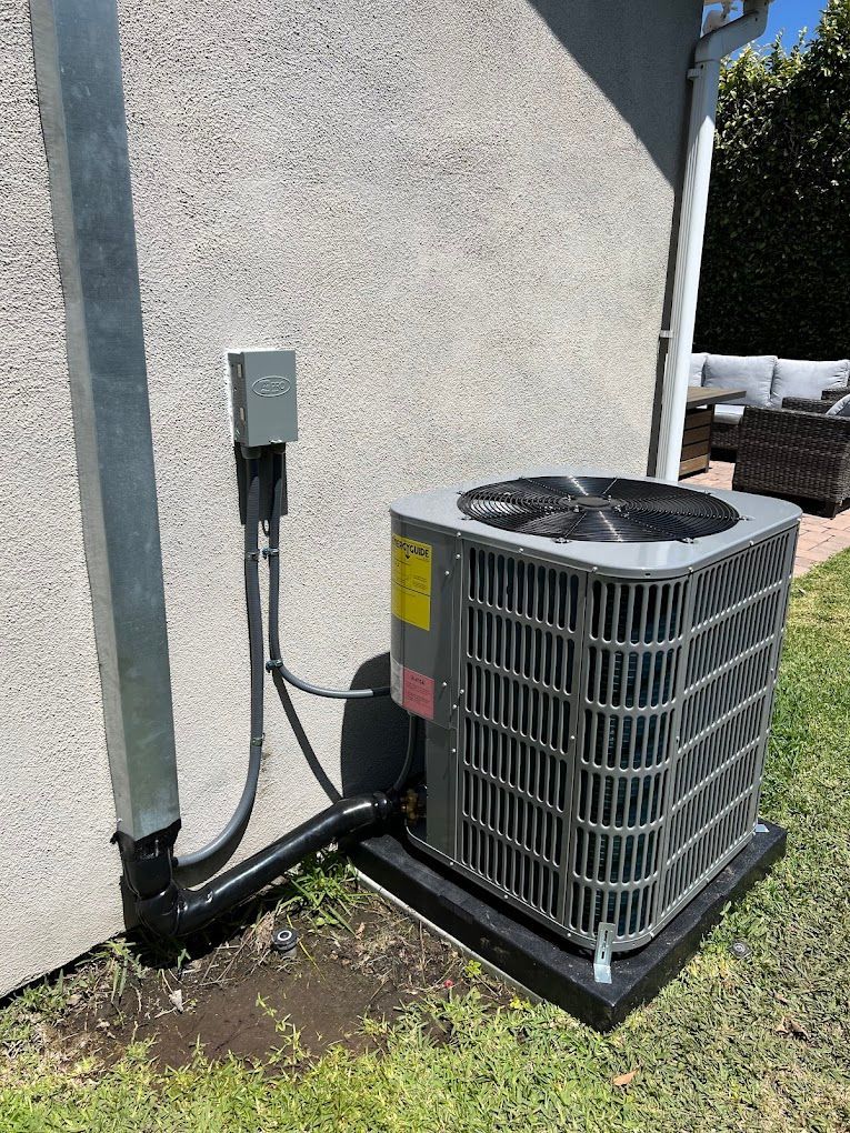 An air conditioner is sitting on the side of a house.